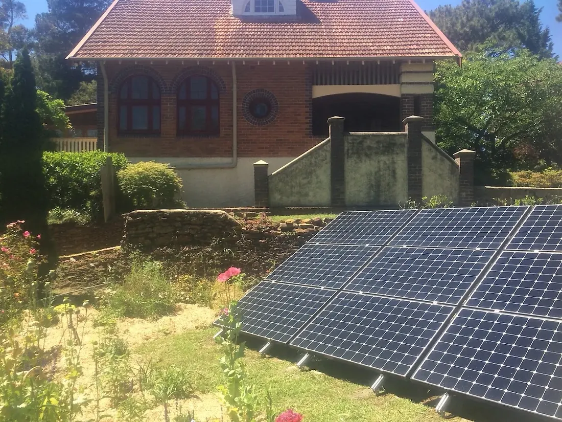 Ground mounted array beside a heritage brick home